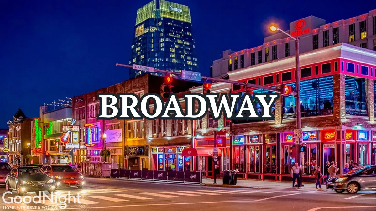 A bustling Nashville street at night, aglow with vibrant neon signs from bars and music venues. The sidewalks are packed with people, and the illuminated buildings radiate an energetic nightlife vibe.