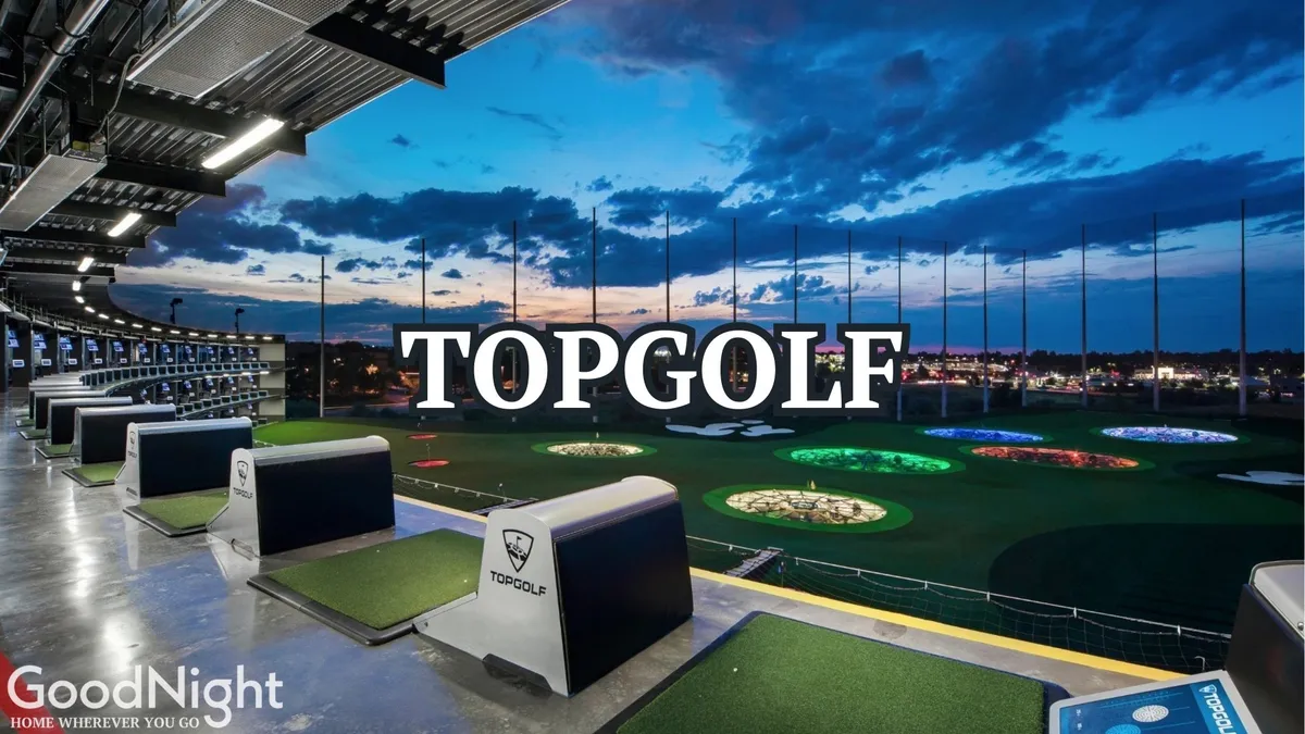 A lively view of Topgolf, showcasing the illuminated targets of the driving range, an open sky with clouds above, and comfortable seating areas nearby. The image radiates excitement and the potential for fun group activities.